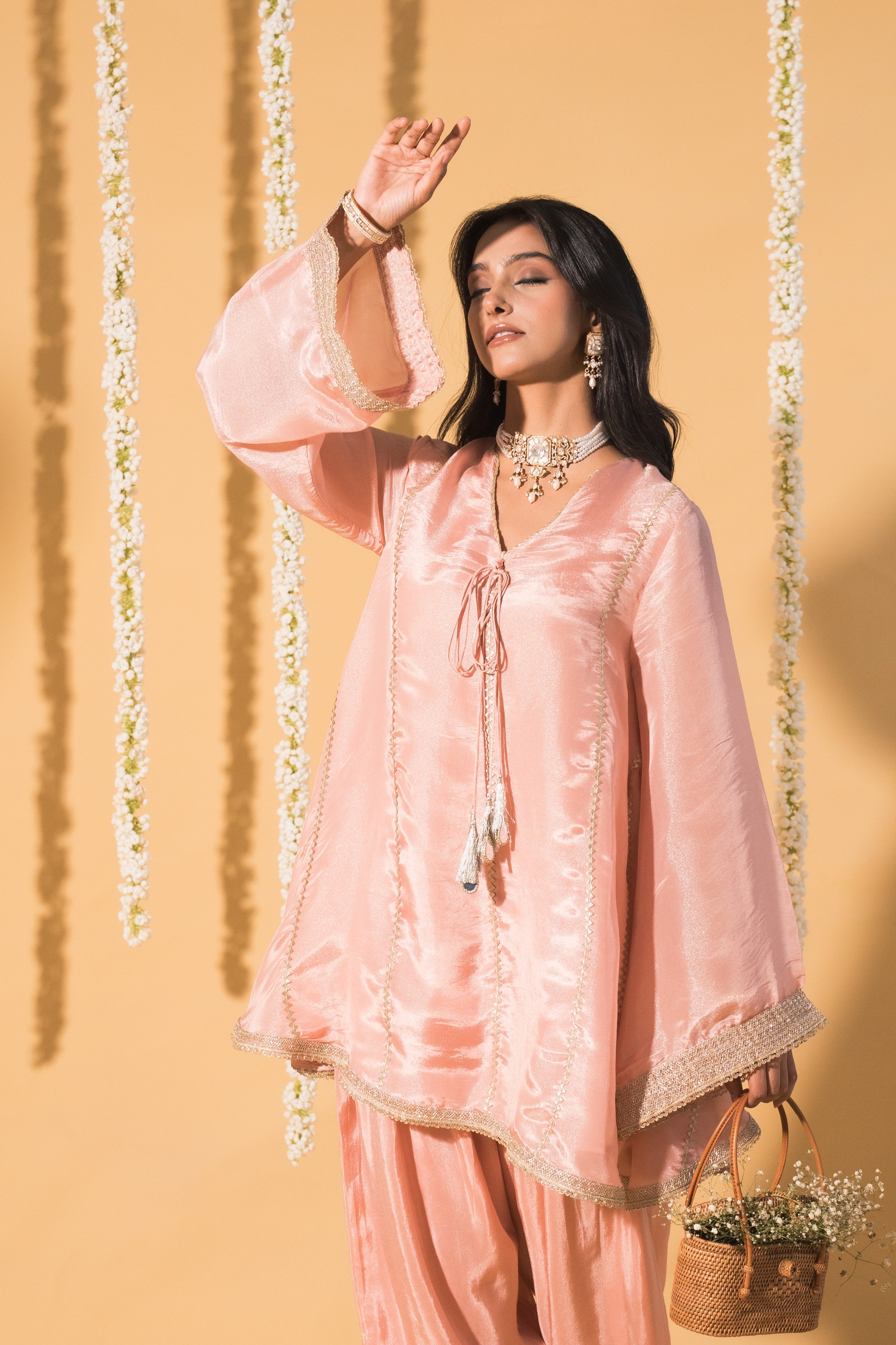 Beautiful Fashion clothing model in pink Indian designer outfit beige background