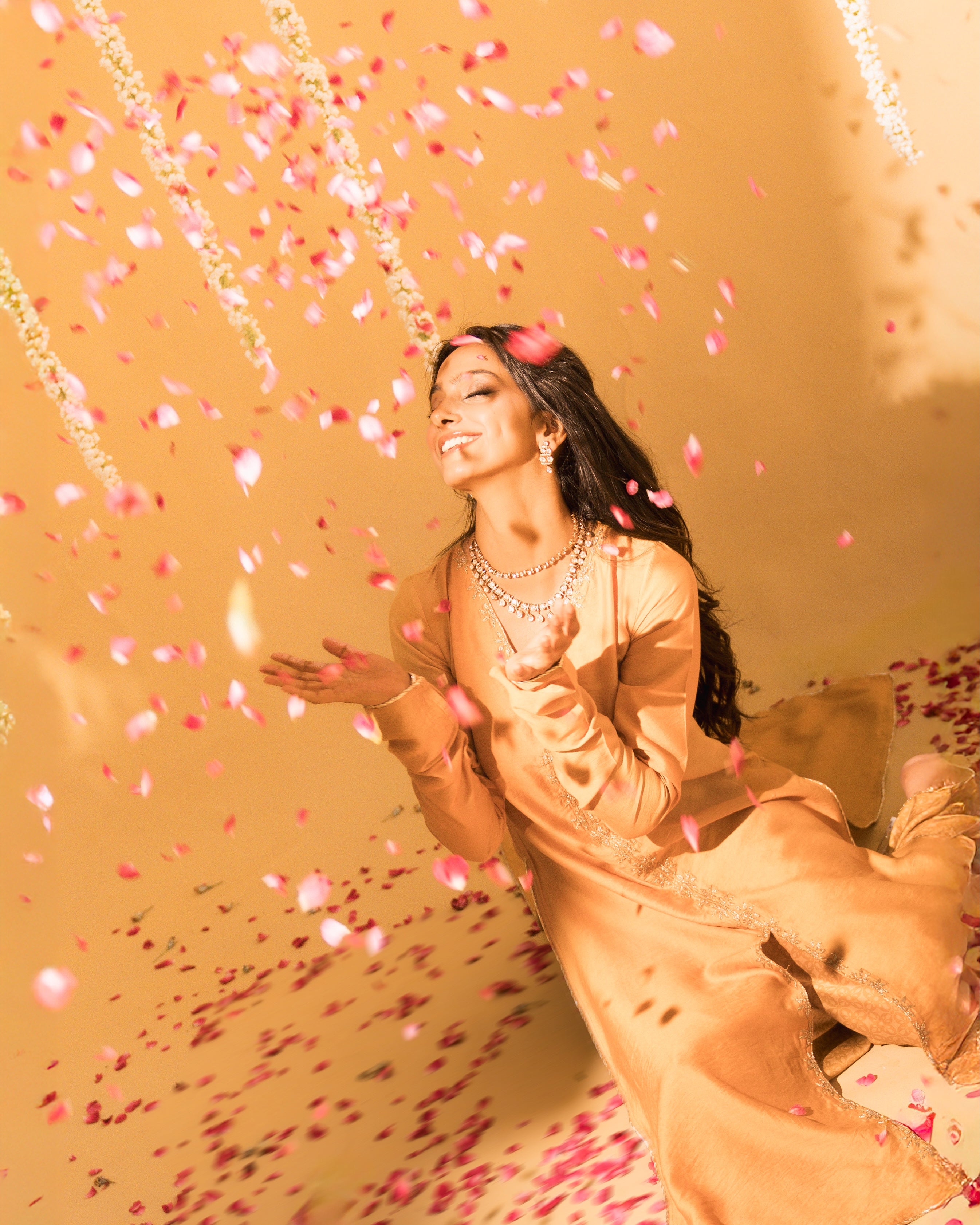 Beautiful Fashion clothing model in Mustard Indian designer outfit playing in rose petals
